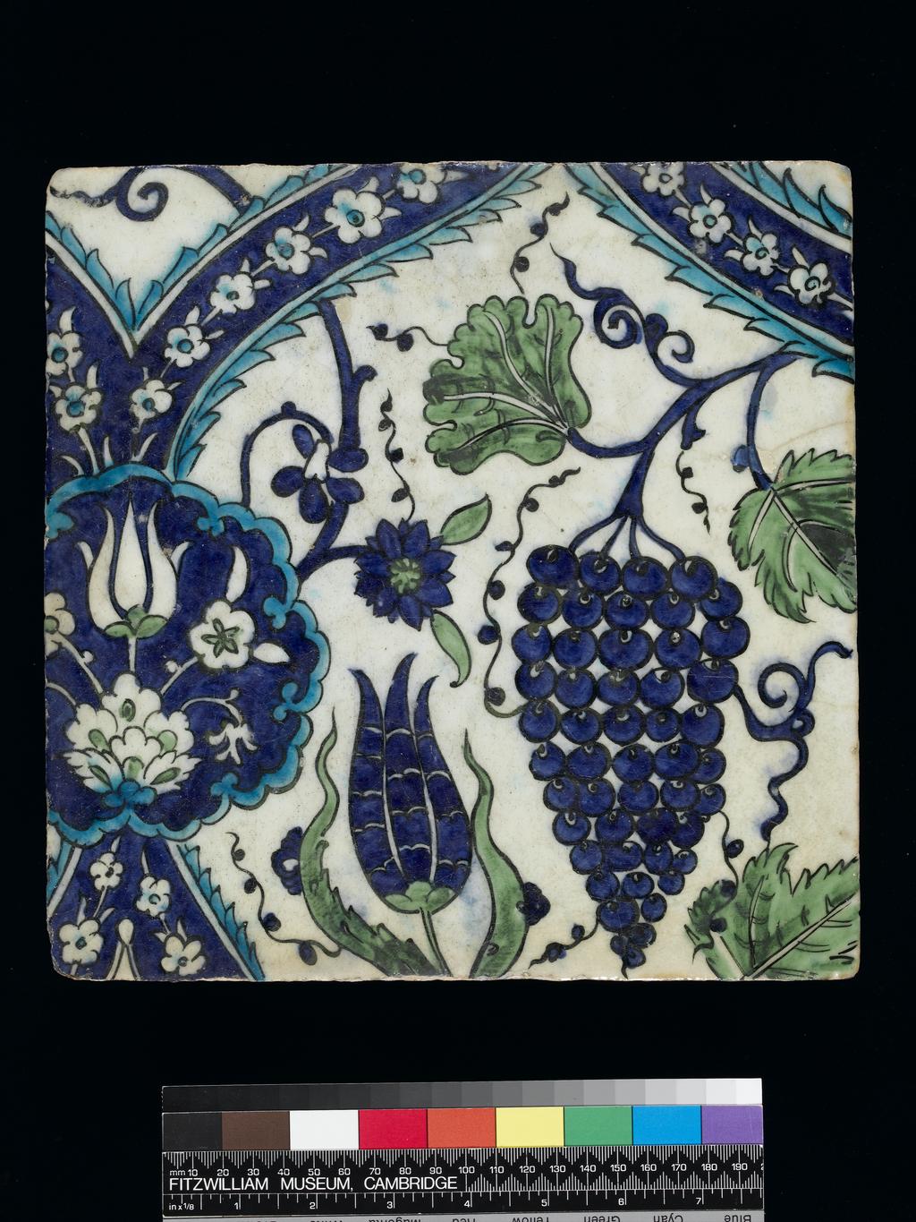 An image of Maker/s: Unknown (potter)  
Description : Part of tile panel (C.4-1928). Pale buff frit body painted in blue, turquoise-blue and green, outlined in black, under a clear glaze. One of eight main field tiles decorated with a reticulated design incorporating medallions, vine sprays, bunches of grapes and tulips
Production Place: Damascus (place), Syria (country) 
Date: 1600 to 1700 
  